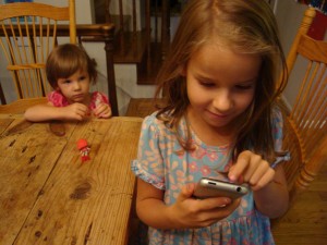 6 year old girl looking sneaking with iphone