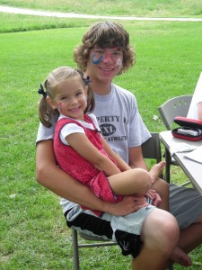 big brother holding little sister at 4th of July picnic