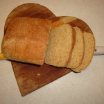 homemade wheat bread on a heart shaped cutting board