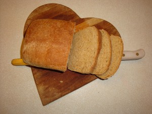 homemade wheat bread on a heart shaped cutting board